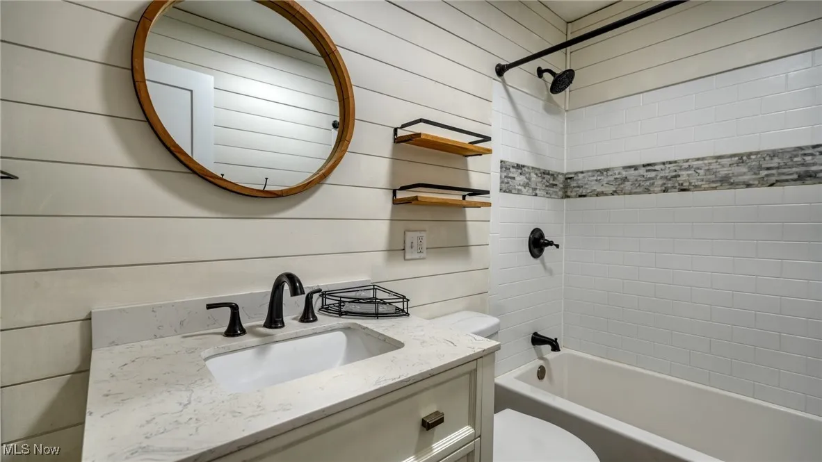 Full bath featuring bathtub / shower combination, vanity, and toilet