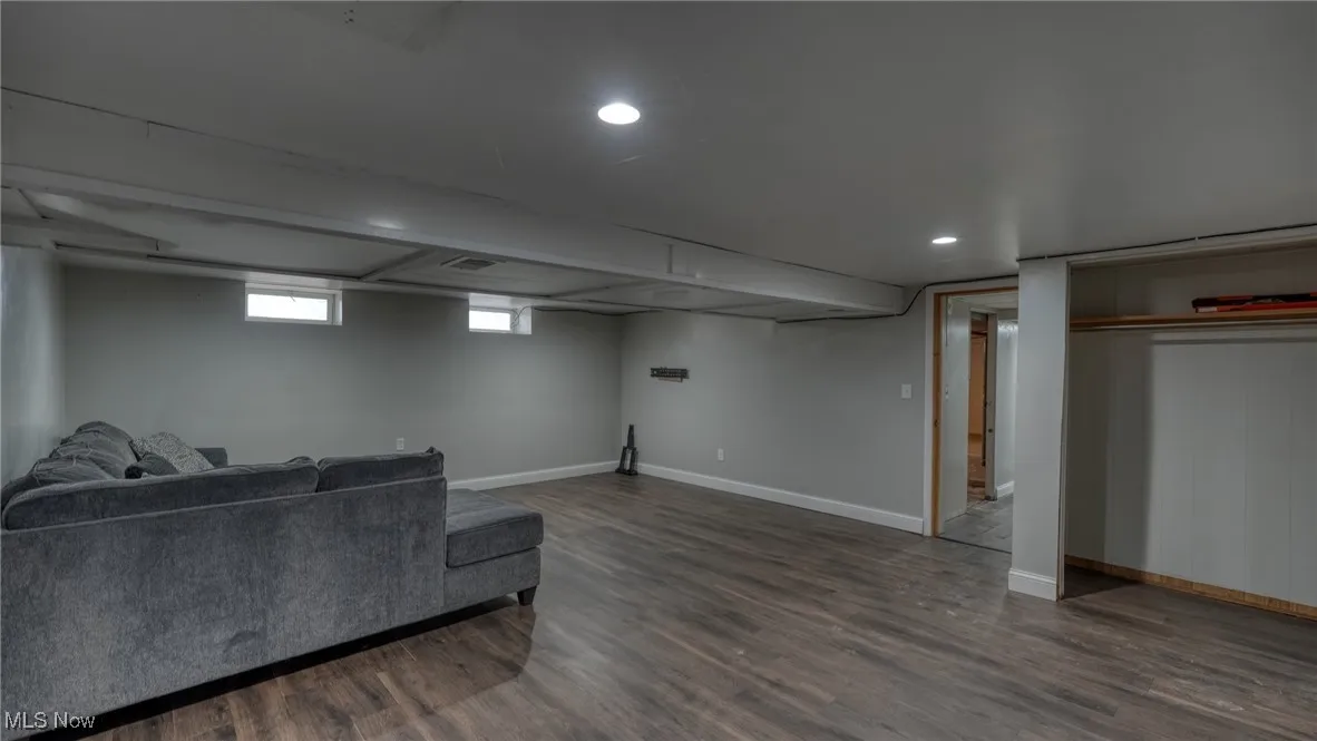 Living area with recessed lighting, visible vents, dark wood finished floors, and baseboards