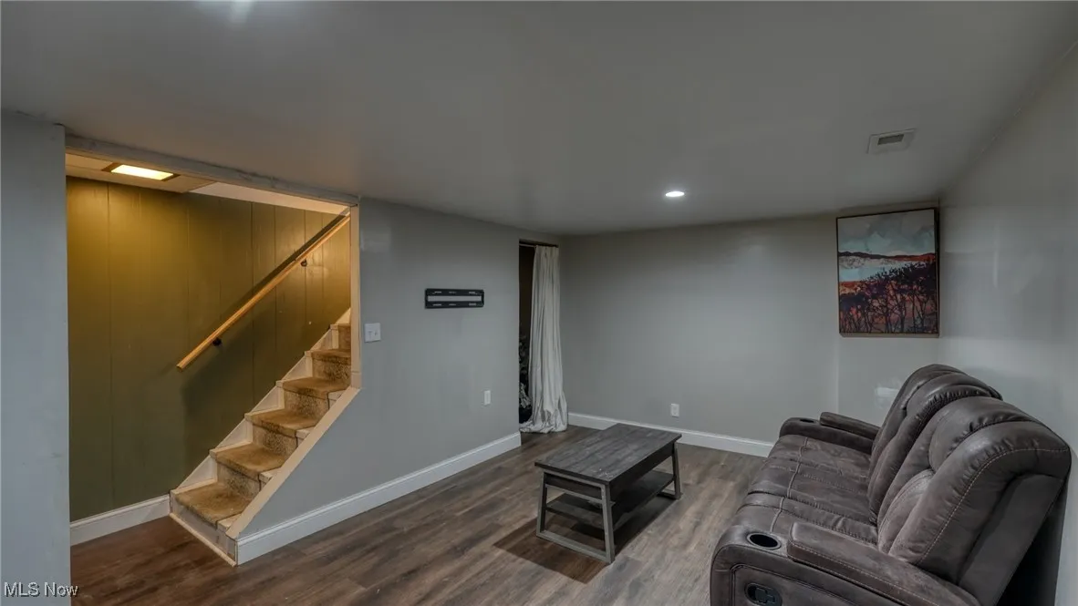 Living area featuring baseboards, visible vents, dark wood finished floors, stairway, and recessed lighting
