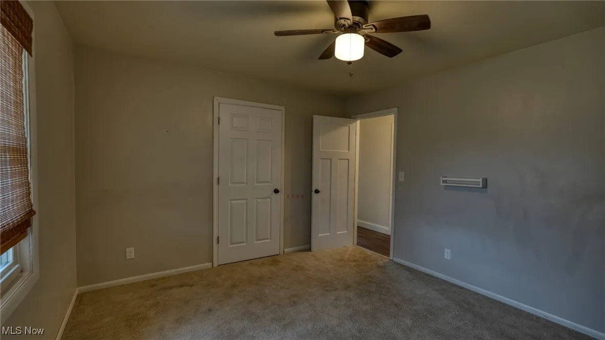 Unfurnished bedroom with carpet flooring, ceiling fan, and baseboards