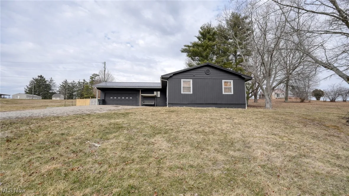 View of front of house featuring metal roof and a front yard