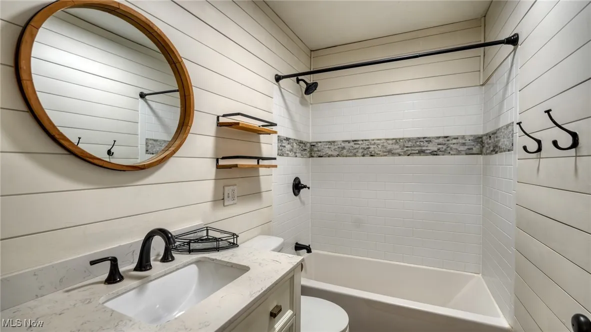 Bathroom with toilet, shower / bath combination, and vanity