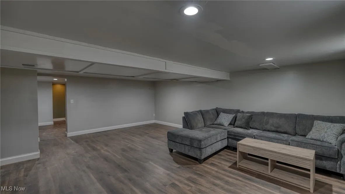 Living room featuring baseboards, dark wood-style flooring, and recessed lighting