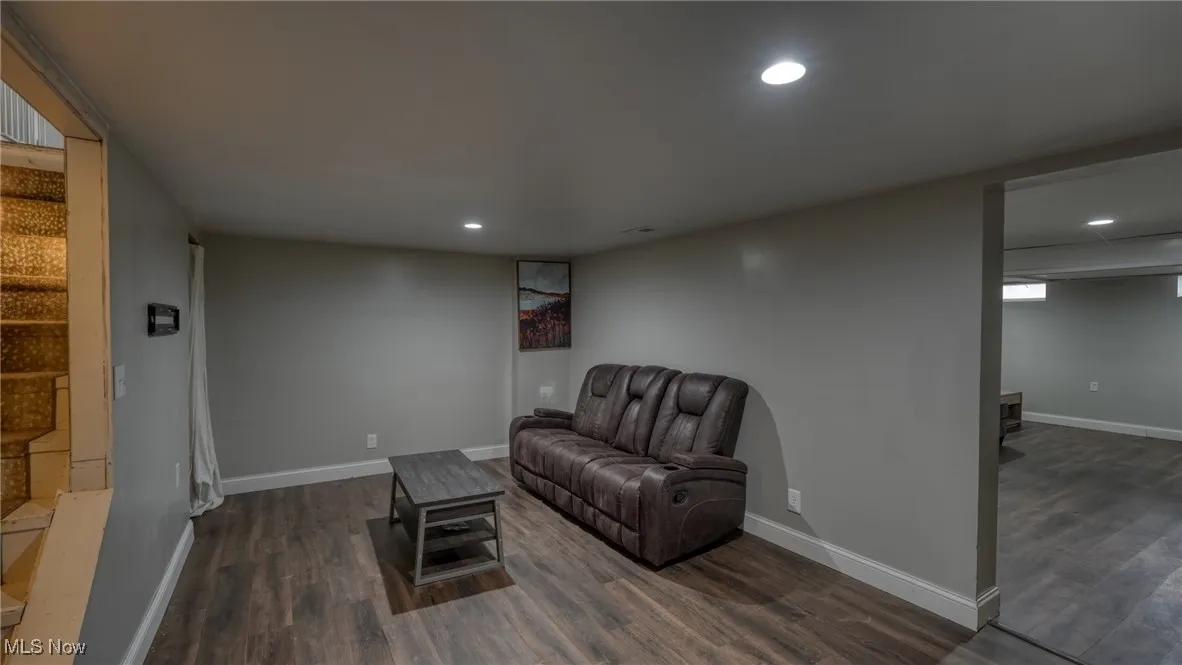 Living area featuring baseboards, dark wood finished floors, and recessed lighting