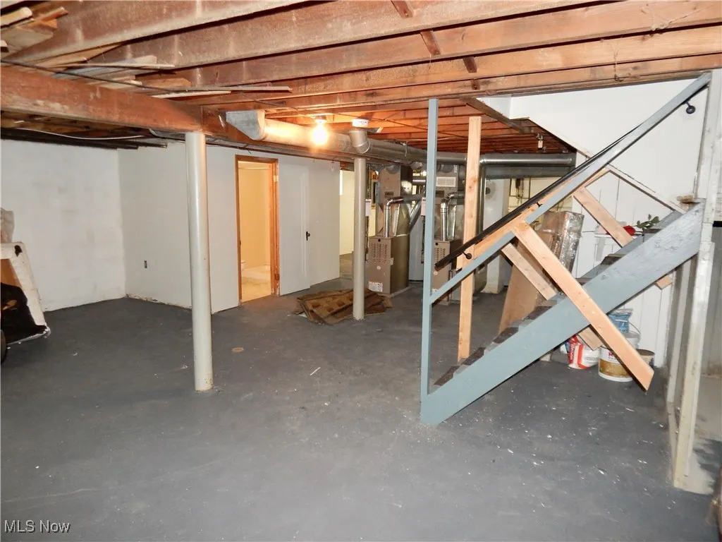 Unfinished below grade area featuring stairway