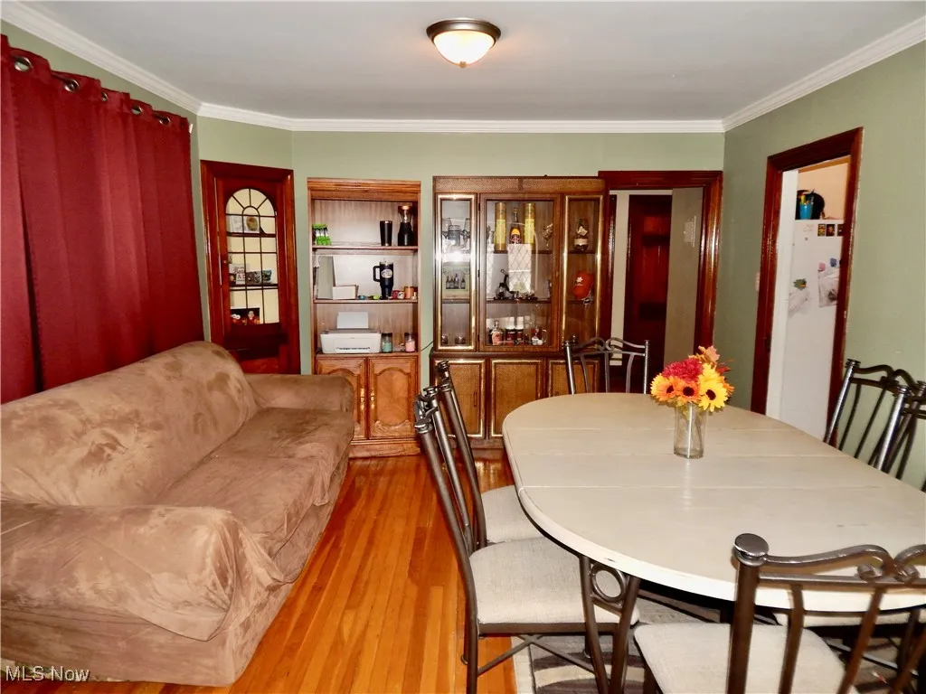 Dining space featuring hardwood floors and crown molding