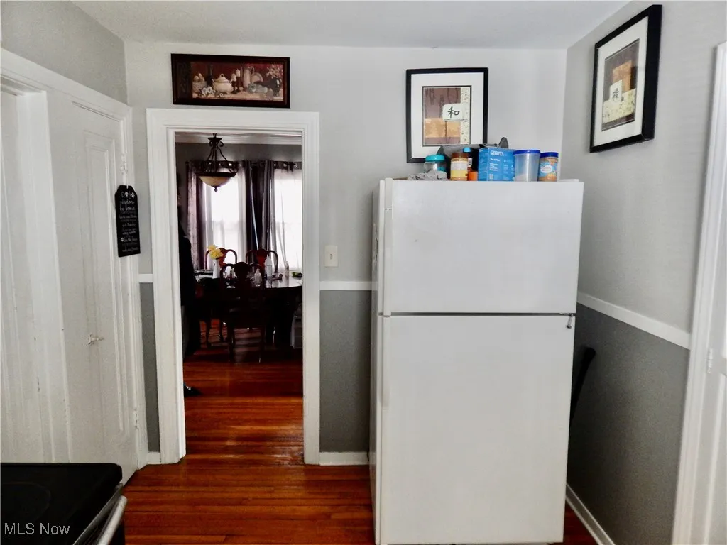 Upstairs unit Kitchen featuring refrigerator, baseboards, electric range oven, and hardwood floors