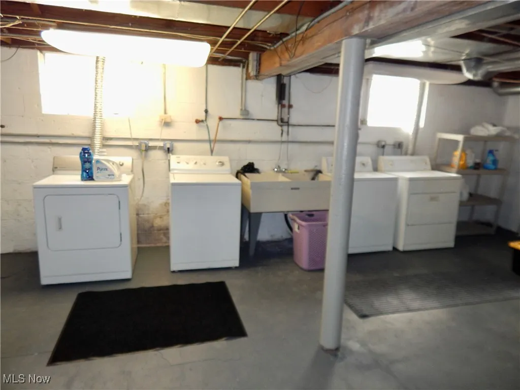 Basement Laundry area featuring washers and clothes dryers