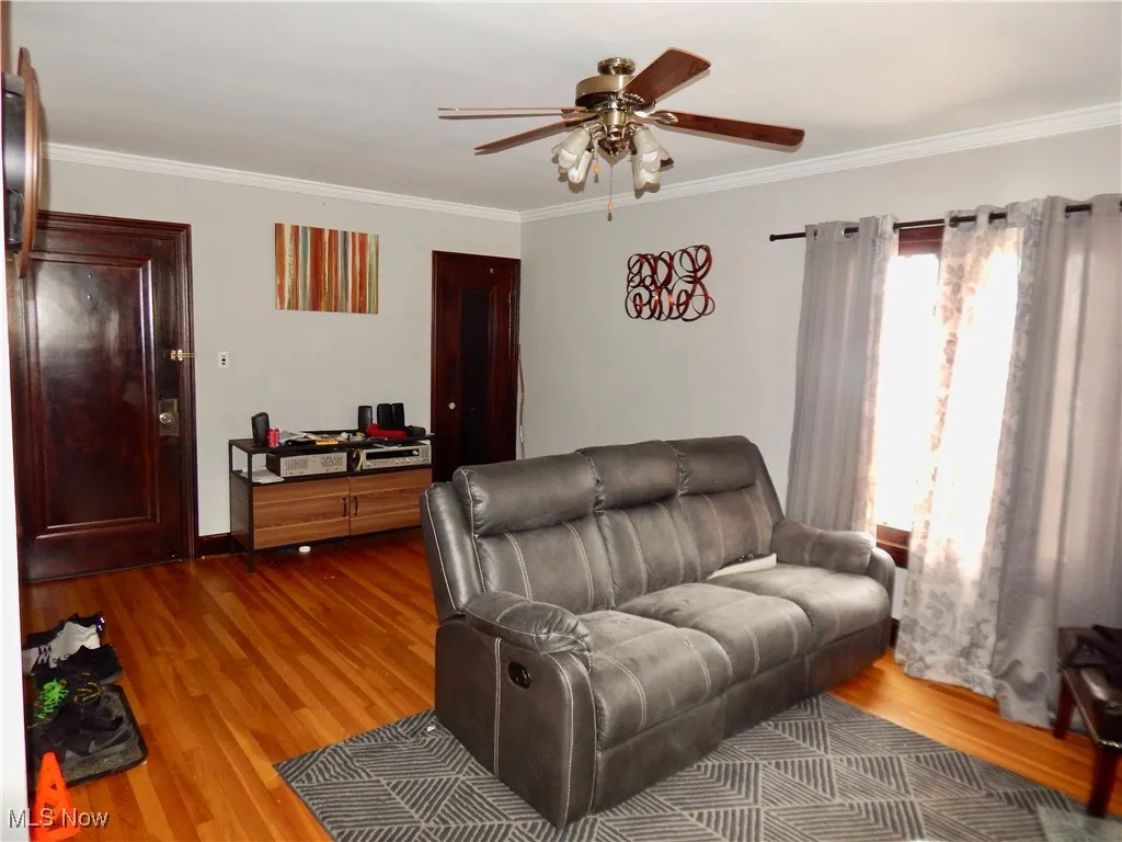 Upstairs unit Living room with ornamental molding, hardwood floors, and a ceiling fan
