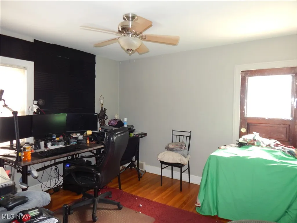 Upstairs unit bedroom with a ceiling fan, plenty of natural light, baseboards, and hardwood floors