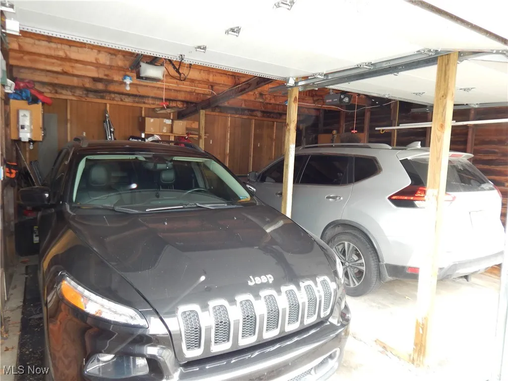 Garage with a garage door opener and wooden walls