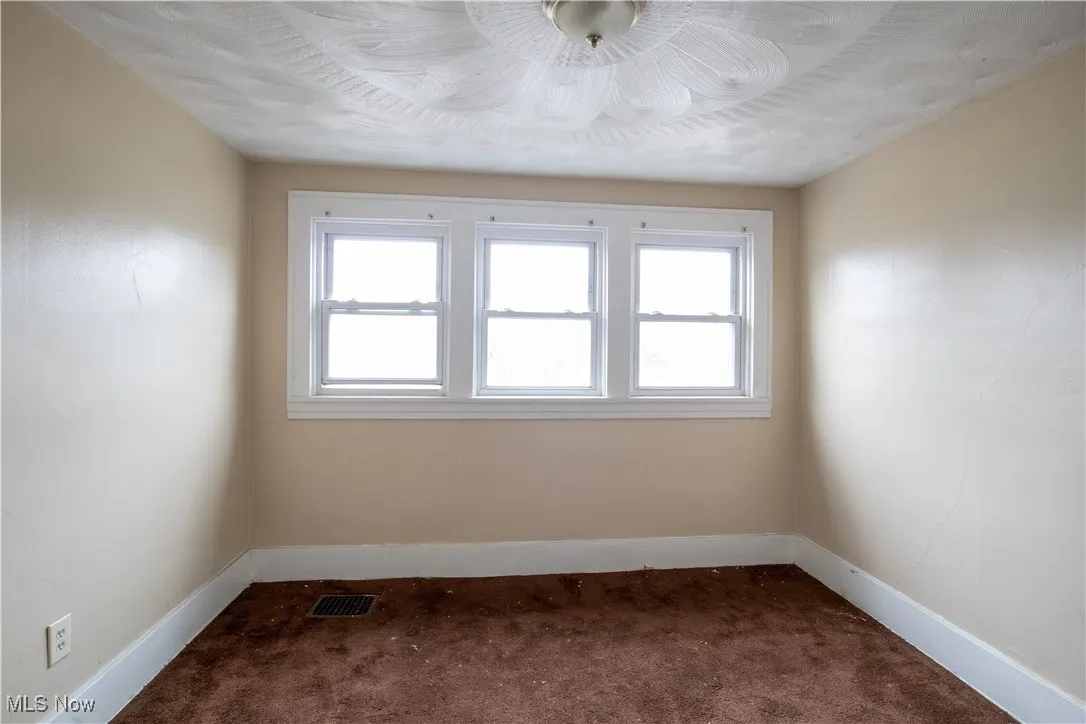 Unfurnished room with dark carpet