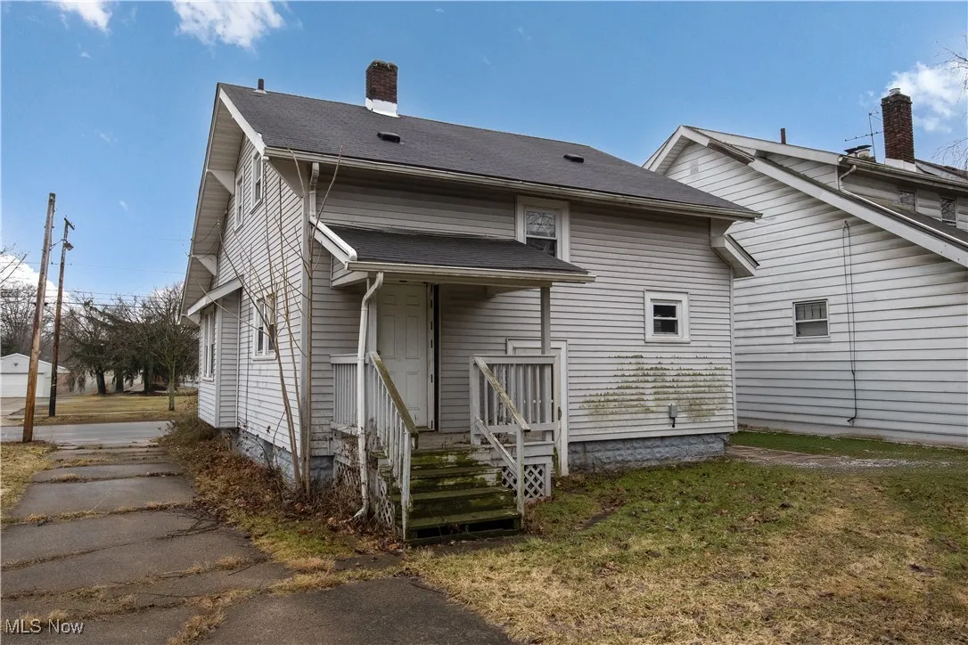 Rear view of house featuring a yard and covered porch