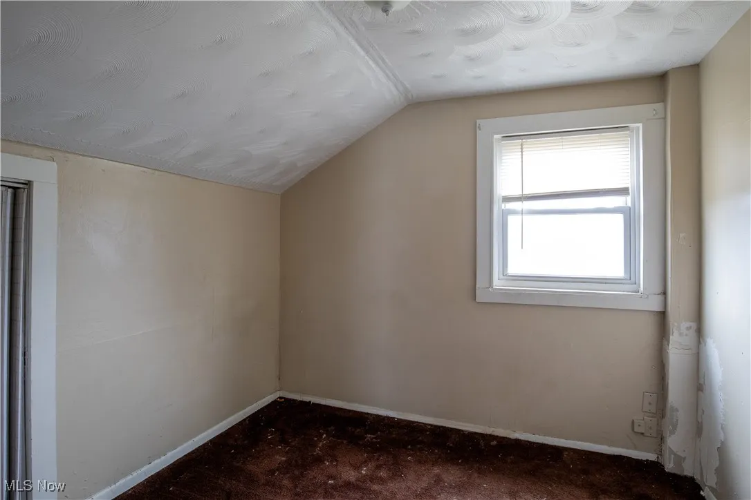 Unfurnished room with dark carpet