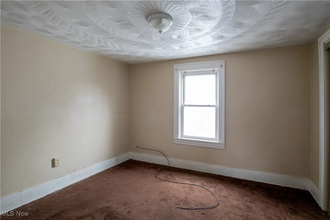 Unfurnished room with dark carpet