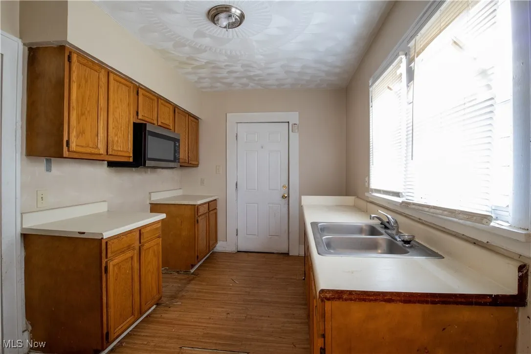 Kitchen with stainless steel microwave, sink, and cabinets