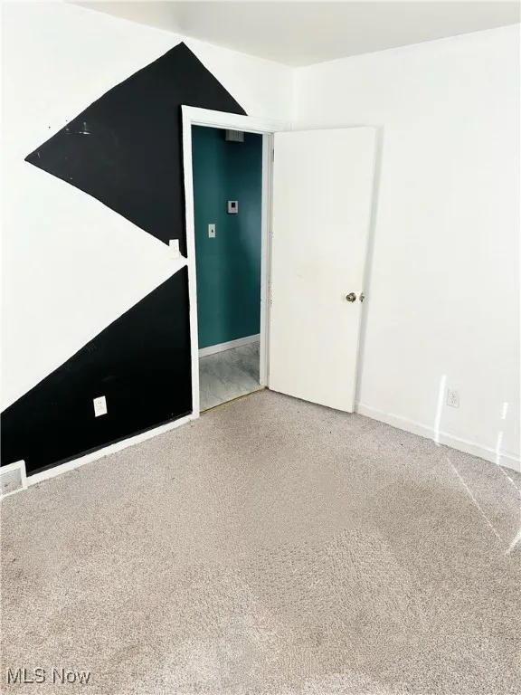 Empty room with carpet floors and baseboards