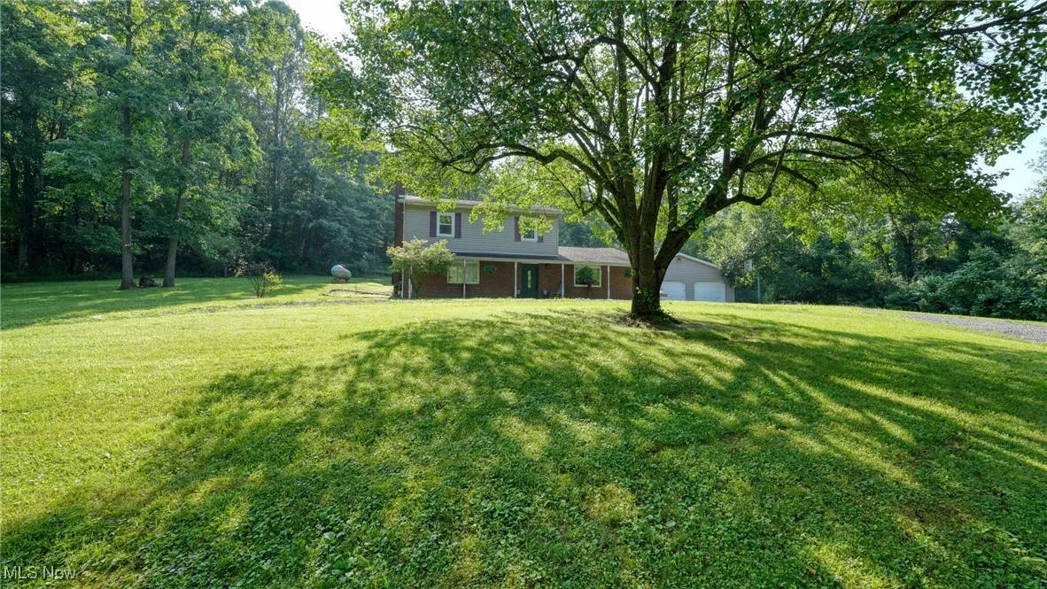 View of grassy yard featuring a garage