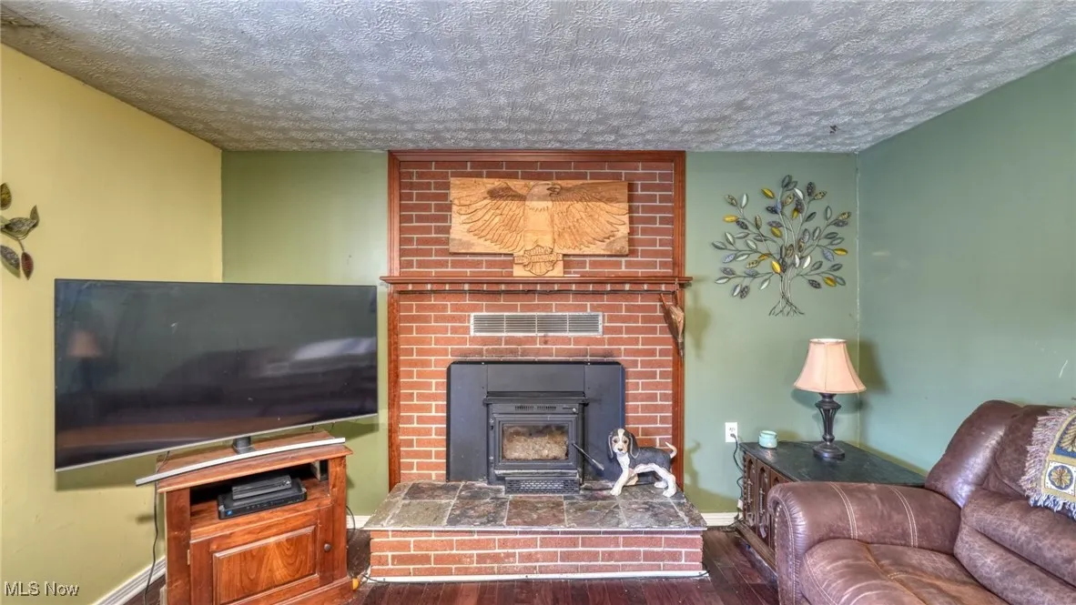 Living room with a textured ceiling and wood finished floors