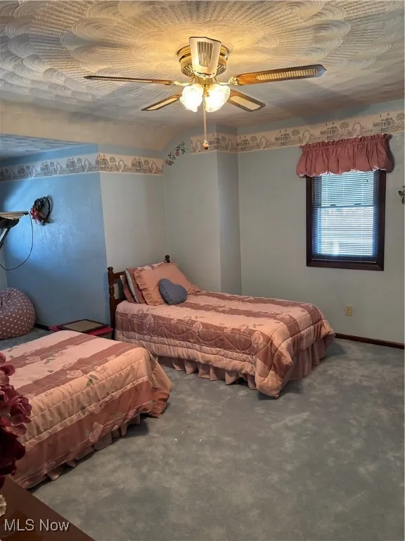 Bedroom featuring ceiling fan and carpet floors