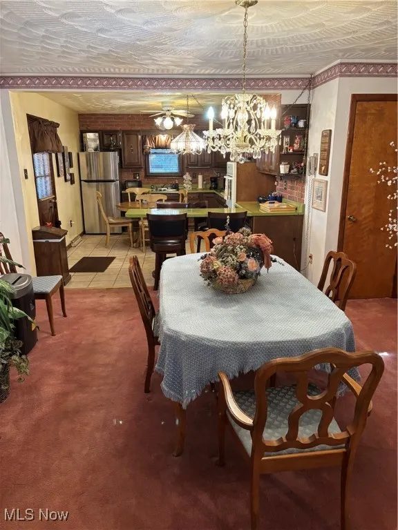 Dining space featuring light tile patterned floors and light colored carpet
