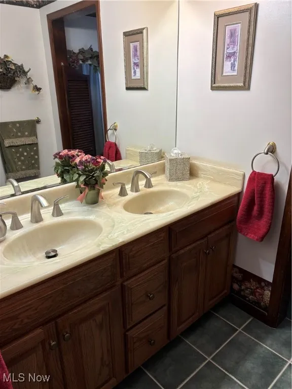 Bathroom featuring tile patterned flooring, a sink, and double vanity