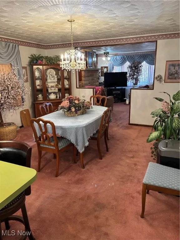 Carpeted dining area featuring an inviting chandelier