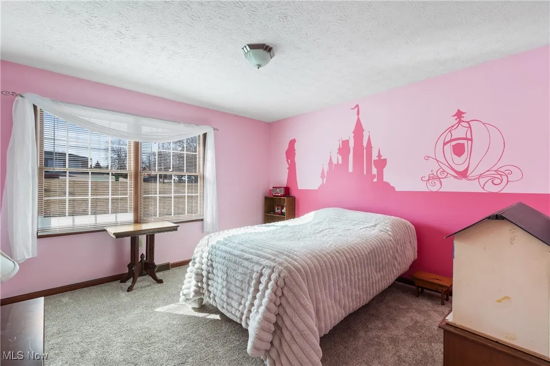 Carpeted bedroom with baseboards and a textured ceiling