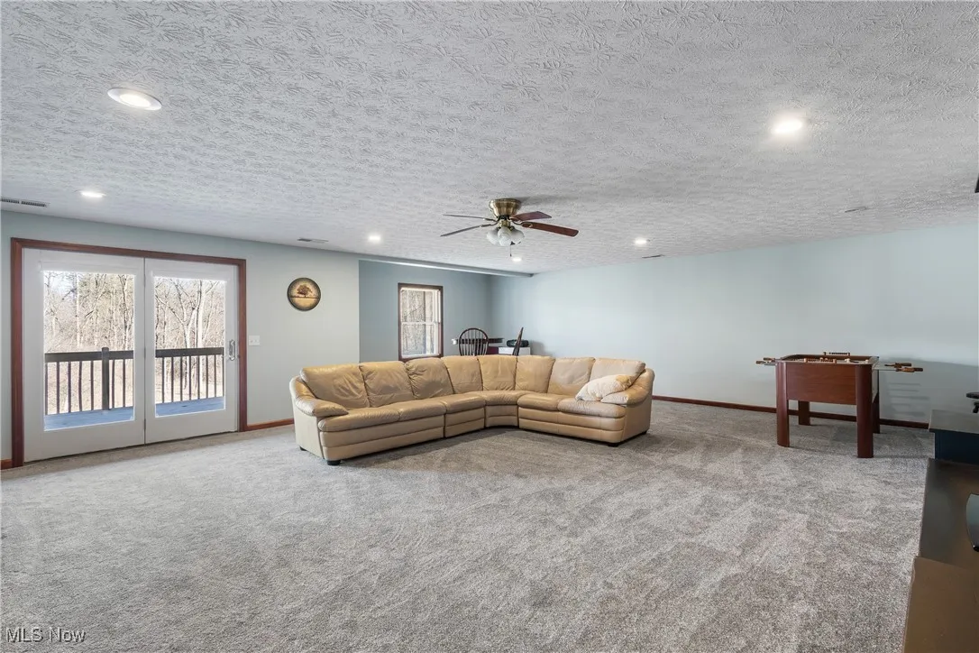 Carpeted living area featuring recessed lighting, visible vents, and baseboards