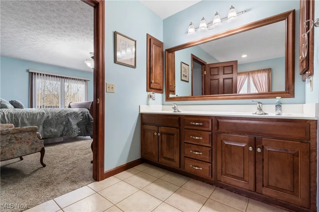 Bathroom featuring double vanity, a sink, and tile patterned floors