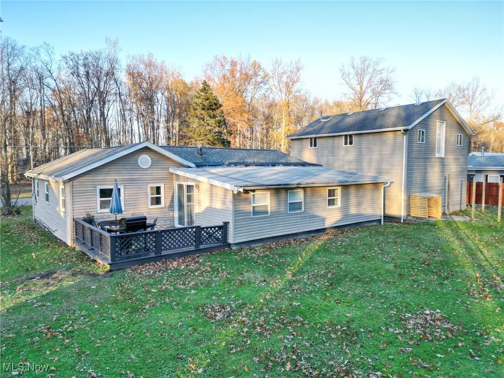 Back of house featuring fence and a yard