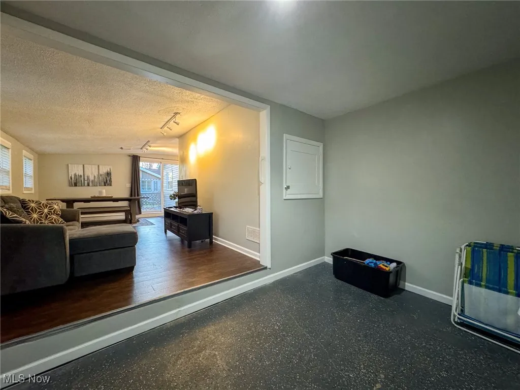 Living area featuring a textured ceiling and baseboards