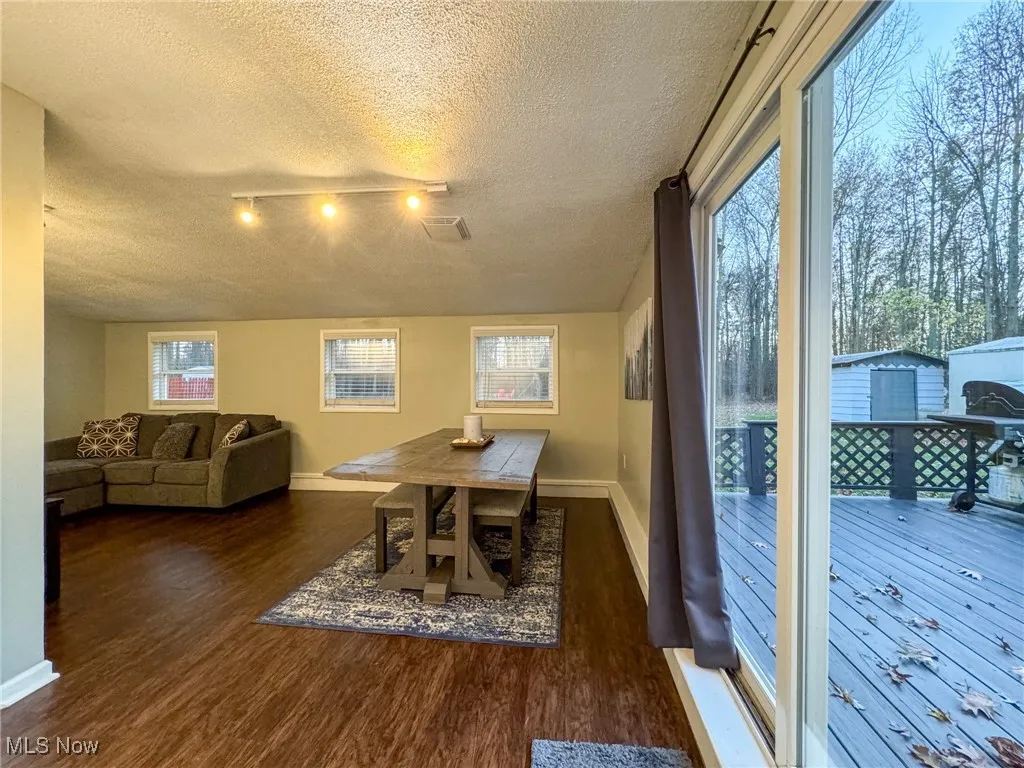 Dining room featuring a textured ceiling, baseboards, and wood finished floors