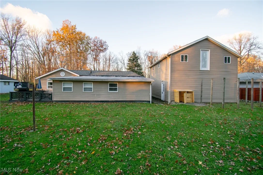 Back of property featuring a lawn and fence