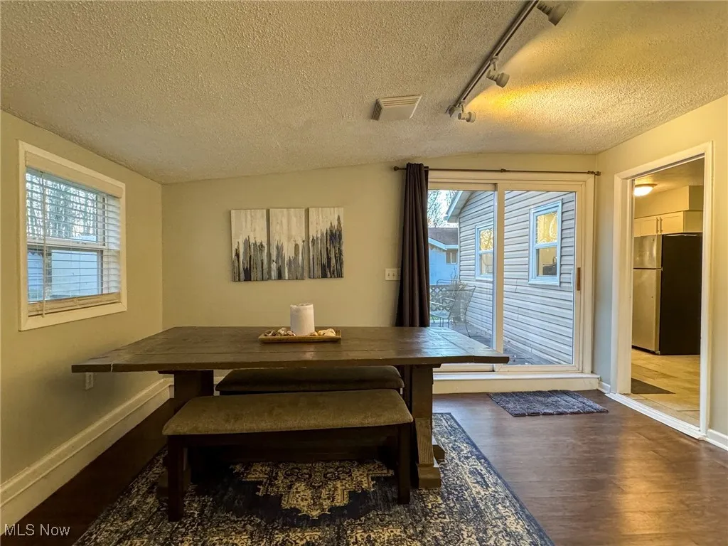 Dining area with breakfast area, wood finished floors, a wealth of natural light, and baseboards
