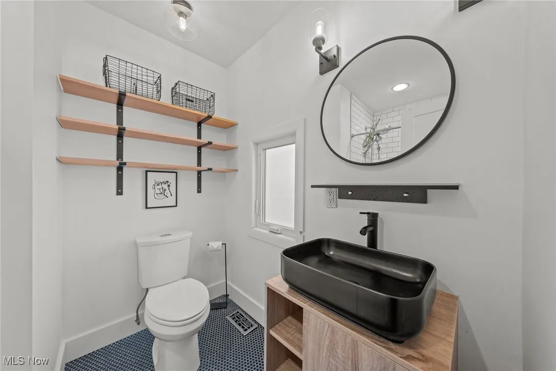 Bathroom with vanity, toilet, and baseboards