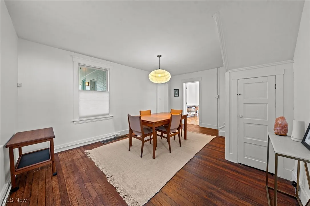Dining room featuring dark wood-style floors and baseboards