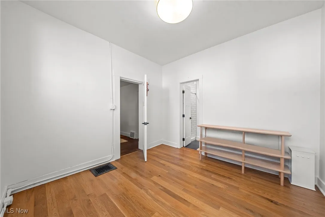 Unfurnished room with baseboards, visible vents, and light wood-style floors