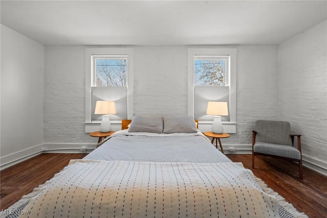 Bedroom featuring multiple windows, wood finished floors, and baseboards