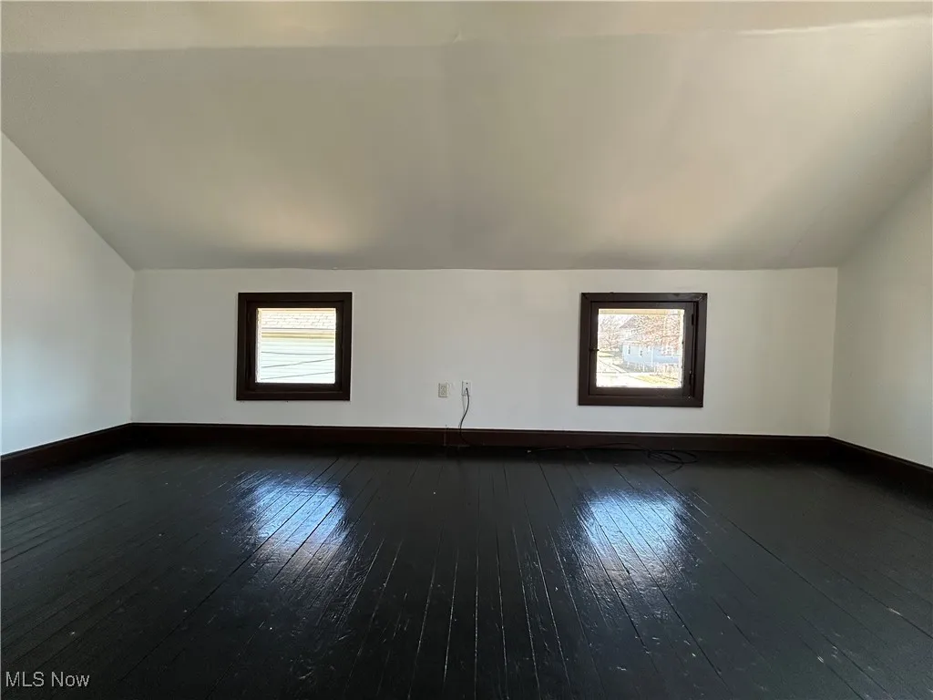 Bonus room featuring plenty of natural light, lofted ceiling, and dark wood finished floors