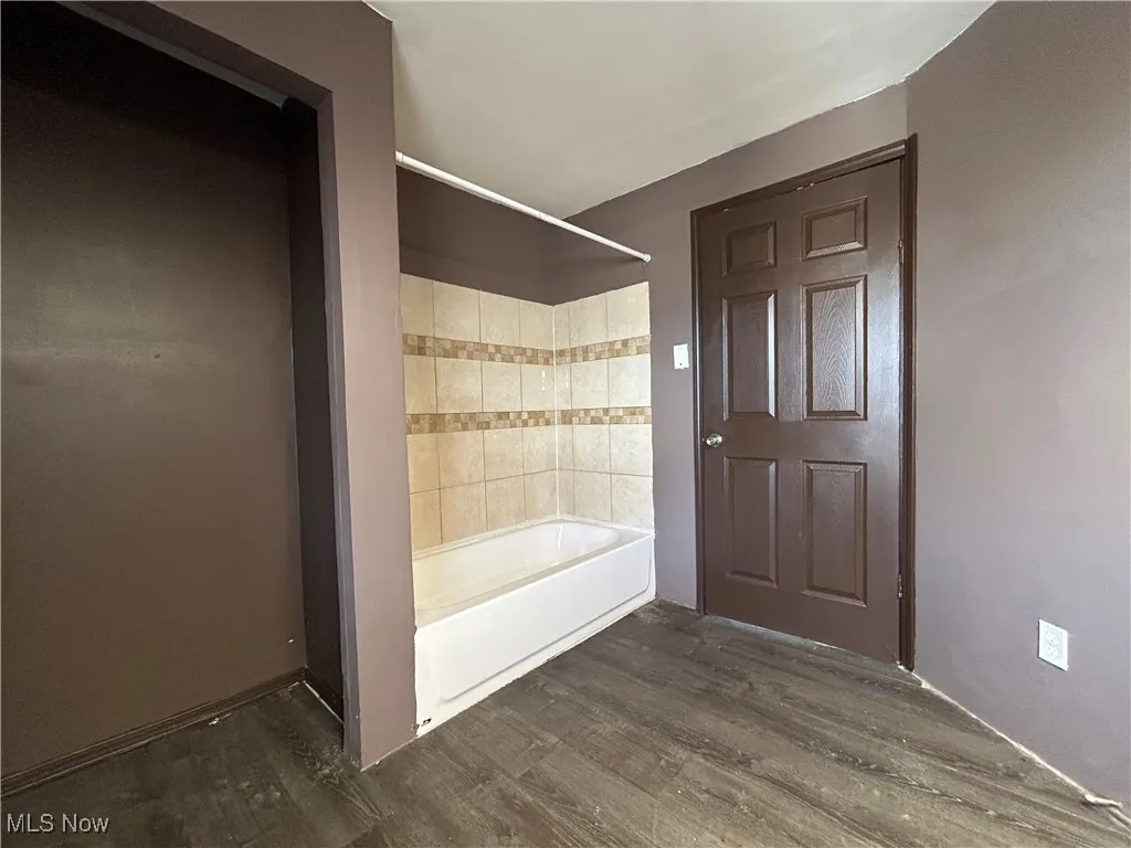 Bathroom featuring bathing tub / shower combination and wood finished floors