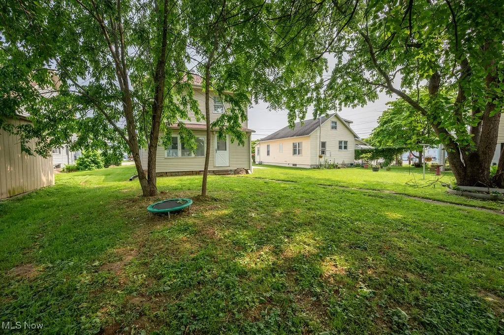 View of grassy yard featuring a trampoline