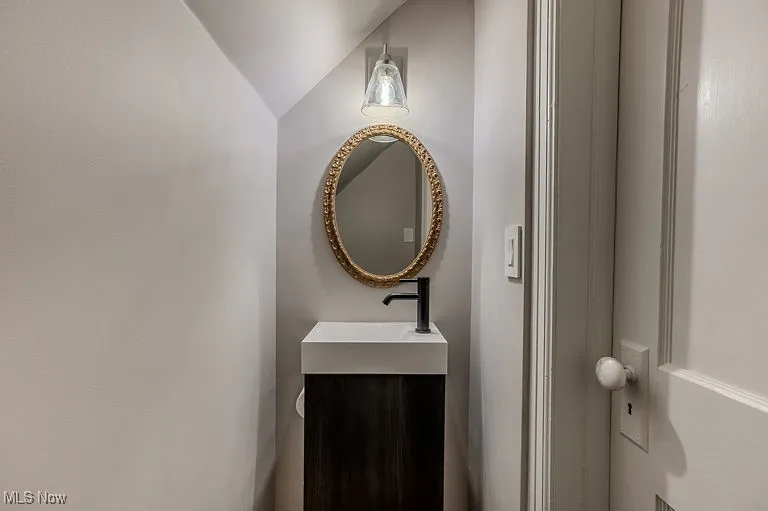 Half bath with vanity and vaulted ceiling