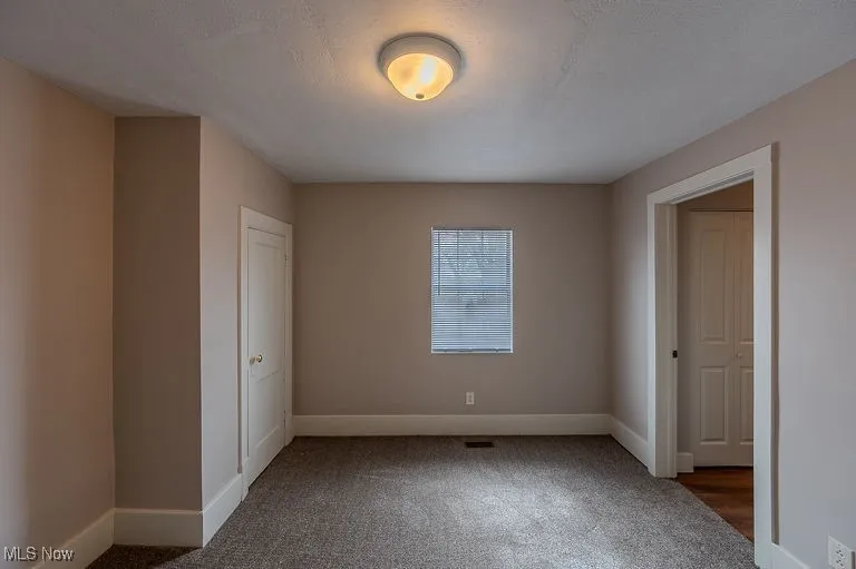 Unfurnished bedroom featuring baseboards, carpet floors, and a textured ceiling