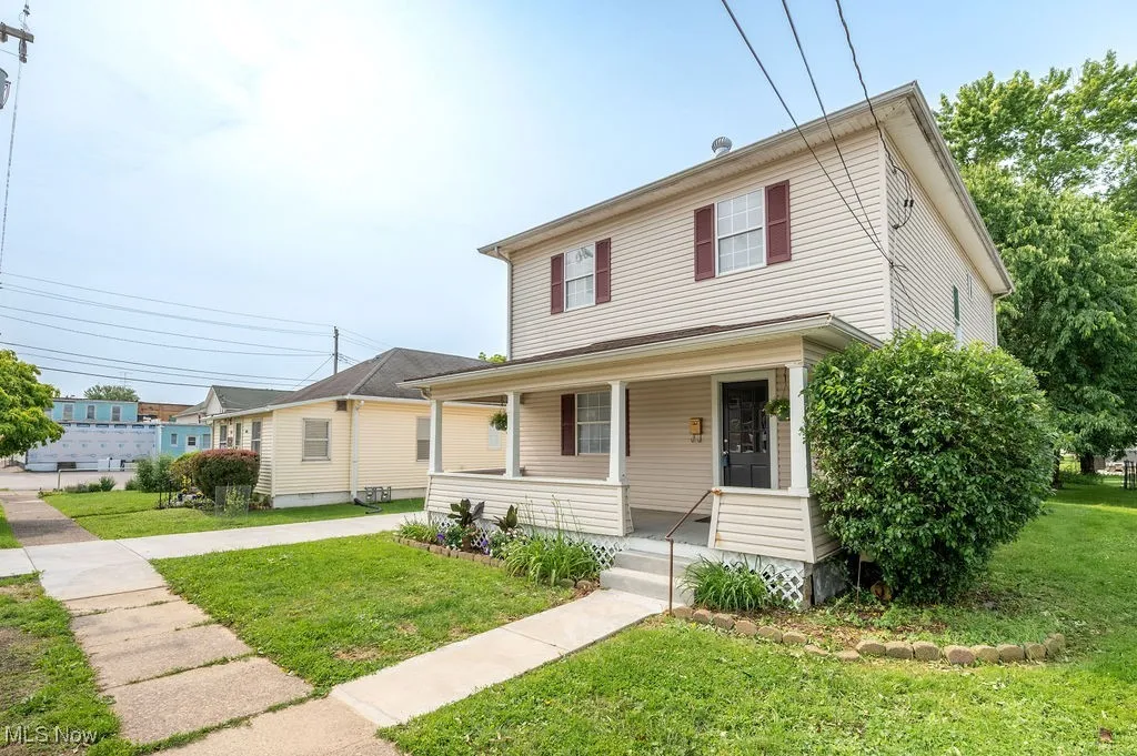 View of front of home featuring covered porch and a front lawn