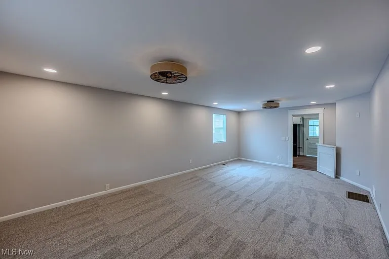 Carpeted spare room with visible vents, recessed lighting, and baseboards