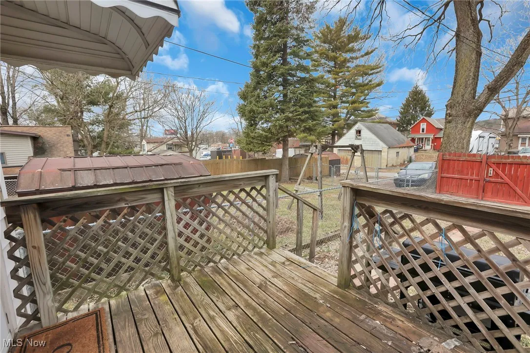 Wooden terrace featuring a fenced backyard and a residential view