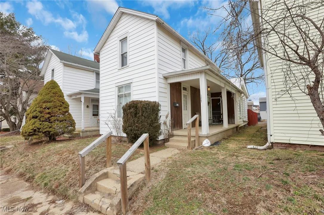 View of front of home with a porch and a front lawn