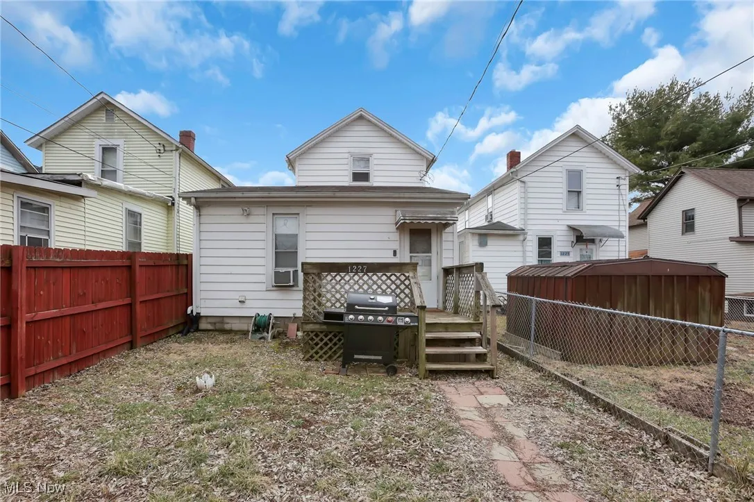 Back of house with cooling unit and a fenced backyard
