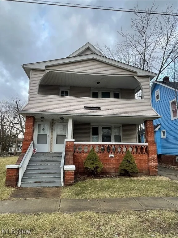 View of front of house with brick siding and covered porch